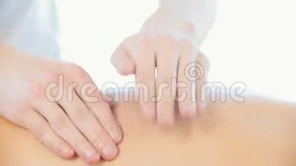 按摩会一位年轻女子接受放松的背部按摩一个按摩师做敲击动作视频的预览图