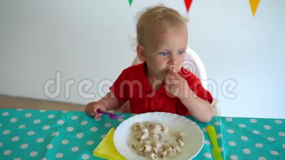 小男孩用叉子吃饺子用另一只手挨着桌子万向节运动视频的预览图
