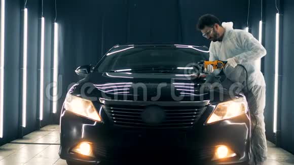 男专业人士正在用一种特殊的仪器汽车引擎盖上抛光视频的预览图