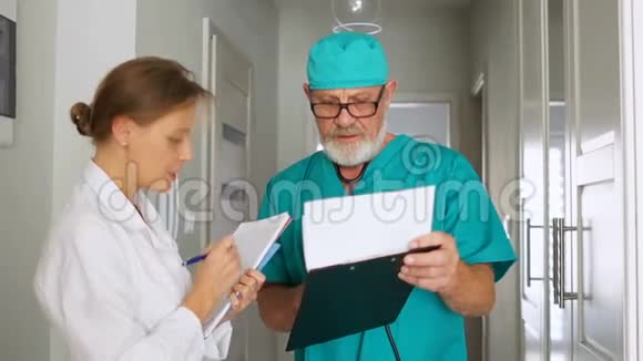 一名穿着白大褂的护士与诊所的医生在文件上签名工作的医务人员视频的预览图