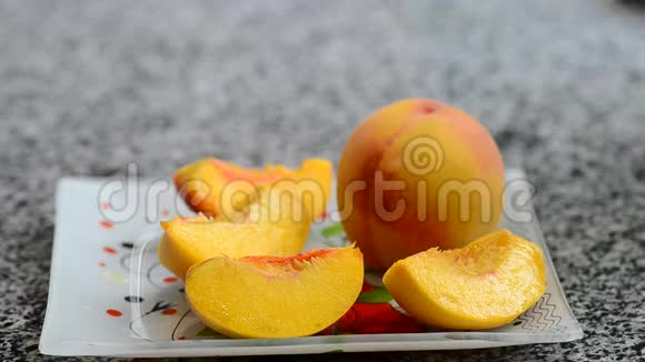 将桃子切成薄片从石头上分离出来把成熟多汁的桃子切片放在盘子里视频柔和的焦点视频的预览图