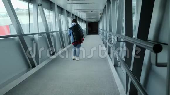 在机场候机楼的门桥上可以看到登机的女游客的背影旅游理念视频的预览图