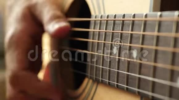 这位音乐家弹着黄色的吉他用手指触摸琴弦视频的预览图