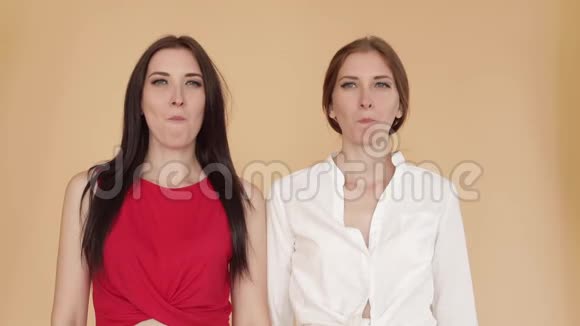 两个穿着便服的女孩一起嚼口香糖和摆姿势视频的预览图
