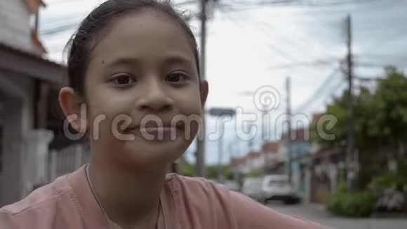 骑着自行车的可爱亚洲女孩的特写照片正在村里微笑视频的预览图