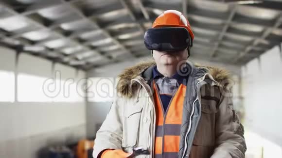 戴着安全帽穿着工作服的人正站在机库的中间准备一把扳手来和虚拟人一起工作视频的预览图