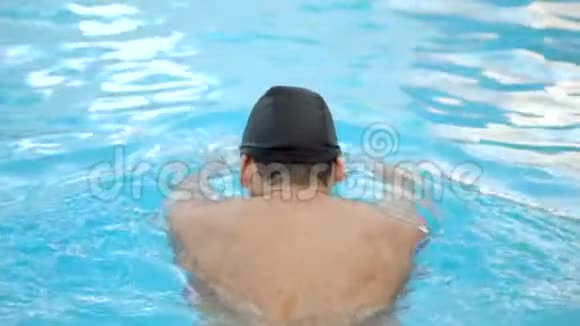 男子游泳运动员在游泳池训练时做蝶泳动作慢动作视频的预览图