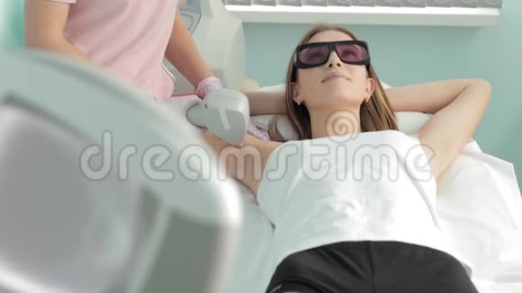 戴眼镜的白种人女孩她的腋毛被水疗中心的女性美容师移除视频的预览图