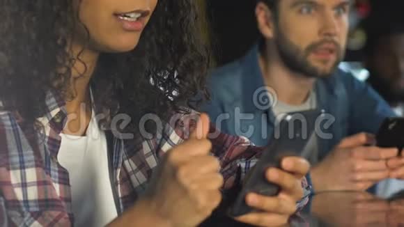 男人和女人在智能手机上查看中奖组合看彩票视频的预览图