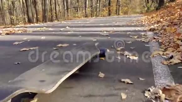 一个孤独的长板滚下柏油路视频的预览图