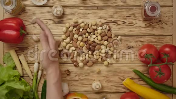 无脸人在木桌上移动坚果健康食品视频的预览图