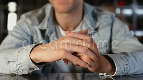紧张的年轻人坐在舒适的咖啡馆里四处寻找女孩约会视频的预览图