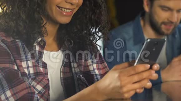 男人和女人在酒吧的智能手机上聊天为孤独的人建立交友网站视频的预览图