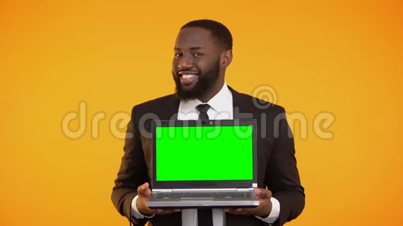 穿着正式西装的美国黑人男性手里拿着预先准备好的笔记本电脑微笑着哇视频的预览图