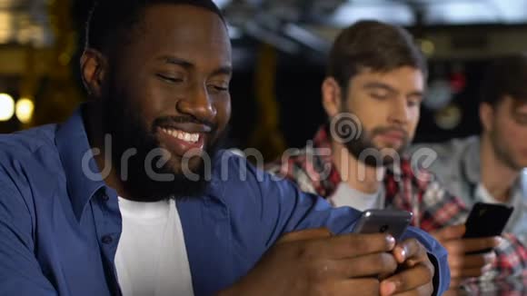 微笑的男人在电话上使用约会网站和女人聊天熟人视频的预览图