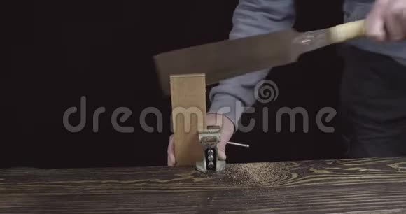 一个木工工匠锯一个木制的细节来制作一个胡子梳子木匠做手工木制梳子电影4K录像视频的预览图