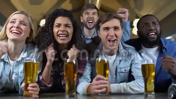 欢乐的球队支持者尖叫着叮叮当当的啤酒杯庆祝进球视频的预览图