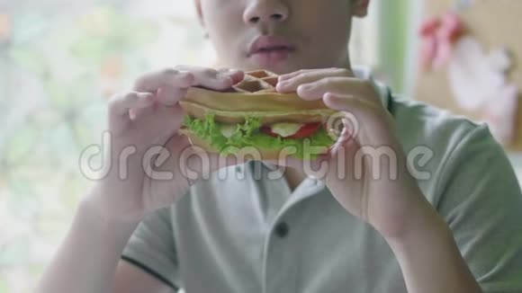 快乐的亚洲男孩喜欢在家吃汉堡包视频的预览图