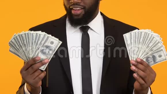 兴奋的美国黑人男子西装革履手捧美元加薪加薪视频的预览图