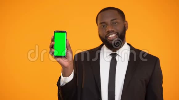 穿西装的黑人男性指向预先准备好的智能手机广告地点视频的预览图