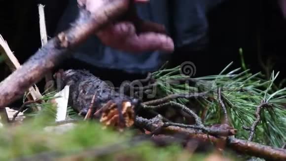 一个穿黑袍的和尚在森林里放柴生火视频的预览图