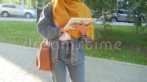 快乐的年轻穆斯林妇女在户外手持数码平板电脑视频的预览图