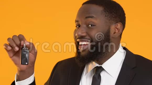 快乐的非裔美国男经理把车钥匙放进相机租房服务视频的预览图