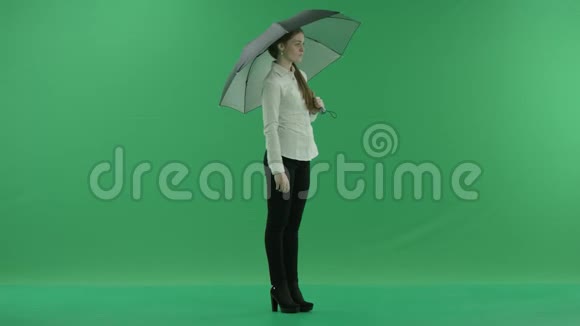 一个体贴的女人站在右边带着雨伞站在绿色的屏幕上她穿着正装白衬衫视频的预览图