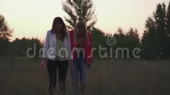 两个女孩在日落时分漫步视频的预览图