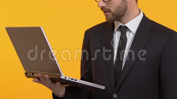 笑容可掬的男人举着笔记本电脑有良好的商业策略和特写视频的预览图
