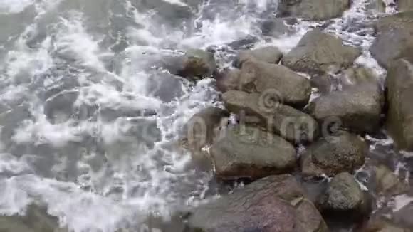 波涛在波涛汹涌的大海中间的一块大岩石上破碎壮观的海浪景色视频的预览图