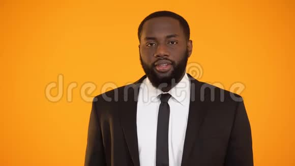 穿着正式服装戴着金色卡片竖起大拇指的时髦微笑黑人男子视频的预览图