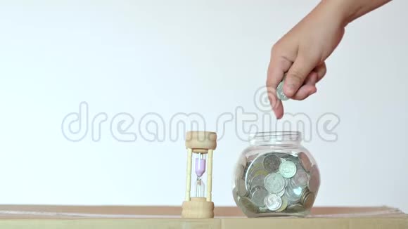 商人把硬币放进玻璃瓶的概念即省钱和投资金融业务视频4K视频的预览图