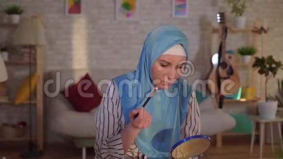 年轻的阿拉伯妇女戴着头巾脸上有烧伤的疤痕正在化妆和哭泣视频的预览图