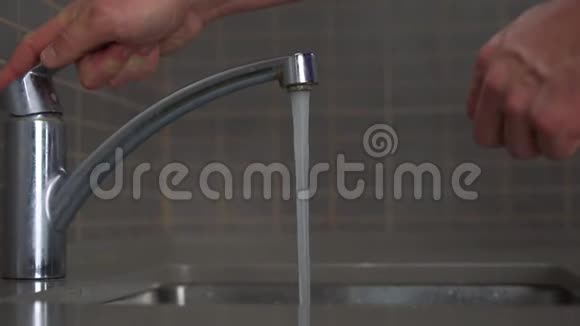 细心的丈夫用洗过的勺子和白色的盘子把水打开视频的预览图