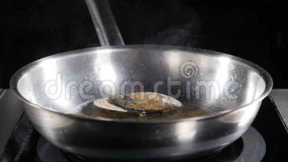 慢动作的食物视频在煎锅上煮海鲜用香料煮海鲜油溅了厨师视频的预览图