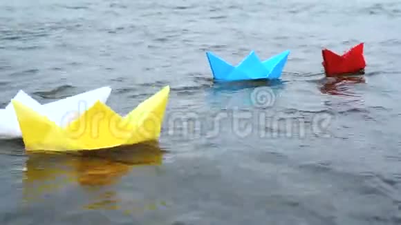 四艘五彩纸船在浪漫的夕阳下在水上航行折纸视频的预览图