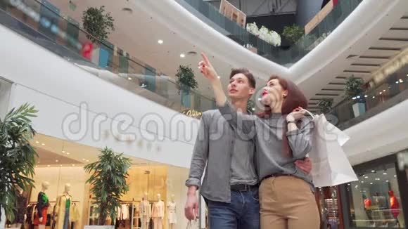 一对年轻夫妇在购物中心四处张望的低角度镜头视频的预览图