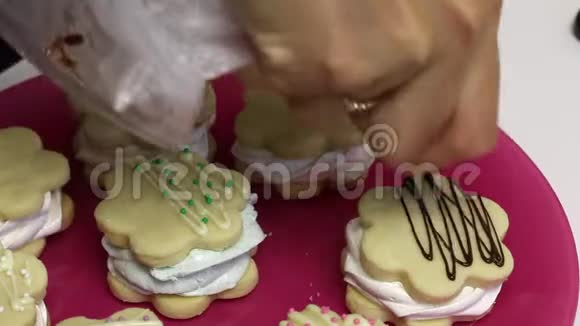 做一个棉花糖三明治空格在盘子上一个女人用巧克力和装饰装饰装饰它们特写视频的预览图