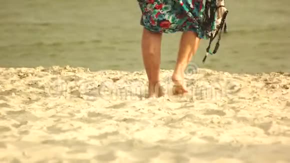 资深妇女在沙滩上散步视频的预览图