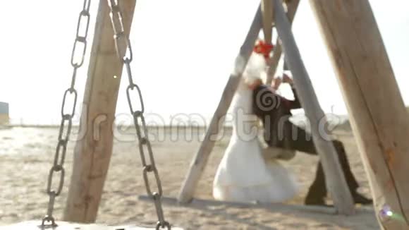 新婚夫妇在秋千上视频的预览图