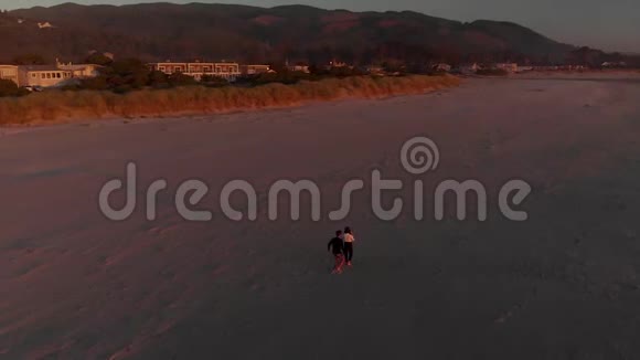 在日落时分一对幸福的夫妇在雄伟的俄勒冈州海滩上拥抱亲吻和旋转视频的预览图