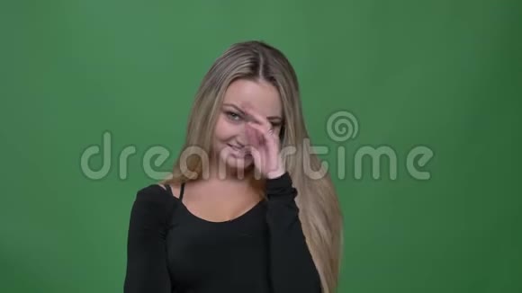年轻女商人穿着黑色衬衫微笑着进入相机在绿色背景下绕着手指旋转头发的肖像视频的预览图