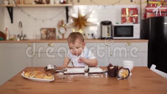 可爱的小厨师准备在厨房的桌子上煮面粉视频的预览图