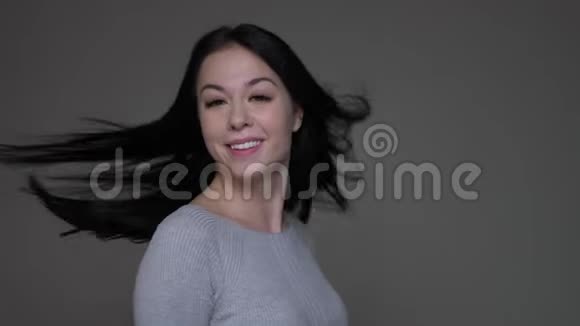 年轻漂亮的褐发白种人女性的特写镜头她的头发飘动拇指朝上视频的预览图