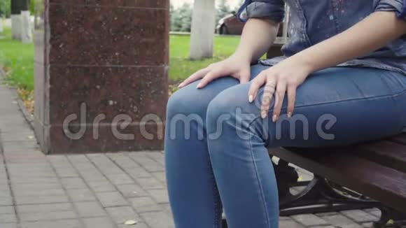站在长凳上的女人感到公园里膝盖剧痛骨关节炎受伤视频的预览图