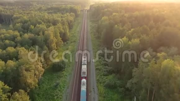 火车驶进远处的俄罗斯森林里日落时的空中景色无人驾驶飞机的4k段录像视频的预览图