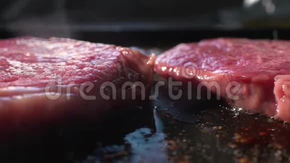 两块多汁的牛排坐在烤架上做饭视频的预览图