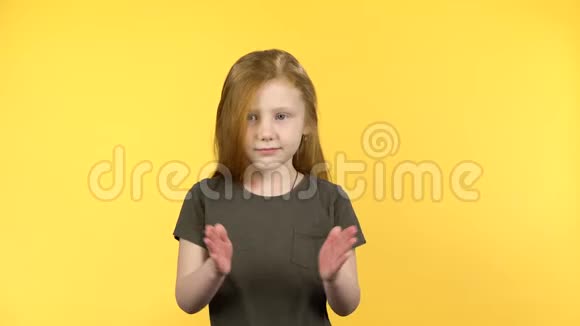 漂亮的女孩在黄色的背景上快乐地拍视频的预览图