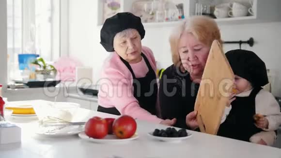 家庭在厨房做甜点一位老妇人正要切香蕉视频的预览图